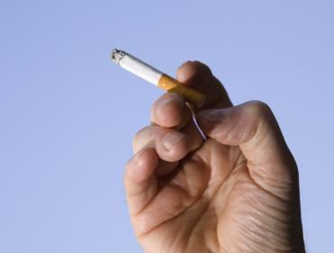 Hand holding burning cigarette