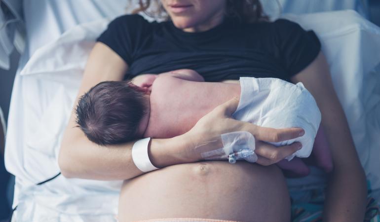 Vrouw in bed geeft borstvoeding