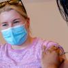 Jonge vrouw krijgt COVID-vaccinatie bij GGD
